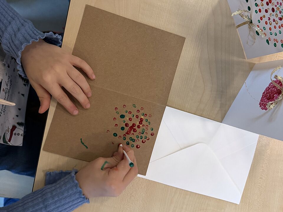 6866 Ein Kind bastelt an seiner Weihnachtskarte.