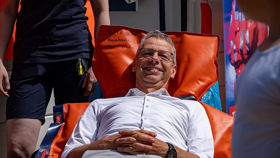 Bürgermeister Beckmann liegt auf der Krankentrage