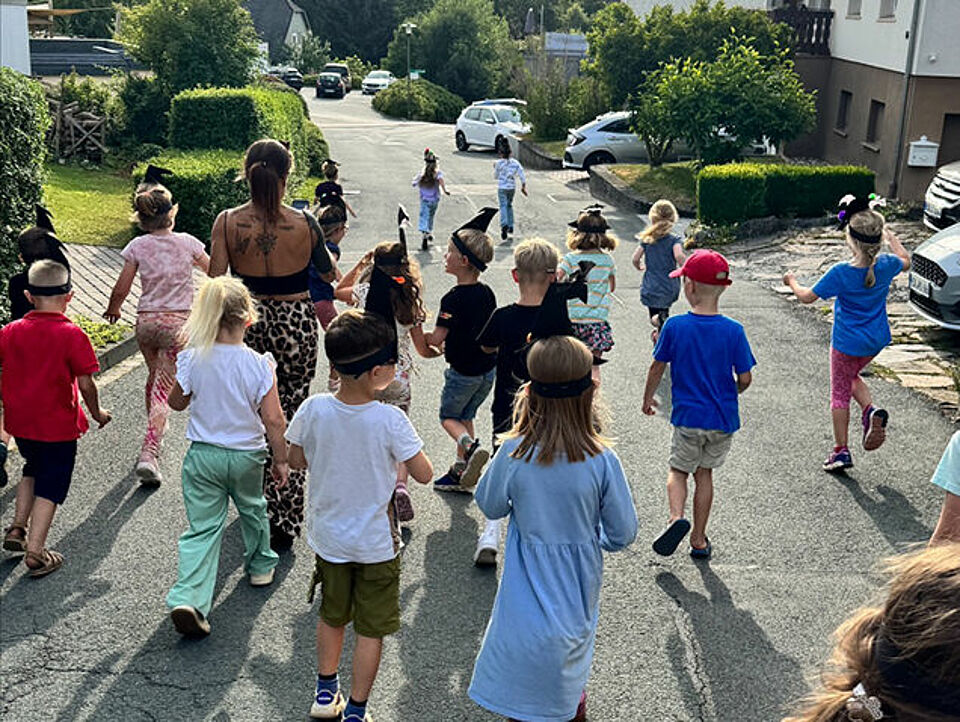Die Vorschulkinder laufen in der Gruppe durchs Dorf und machen eine Schnitzeljagd.