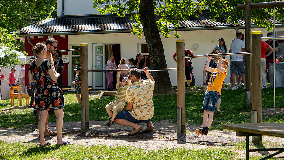 Kinder und Erwachsene an den Turnstangen