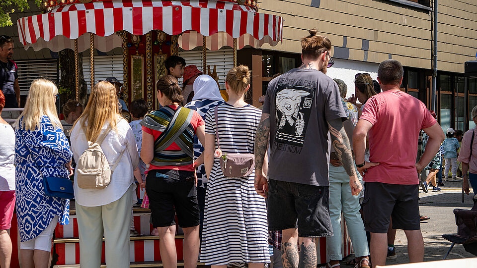 Eltern stehen vor dem Kinderkarussell 