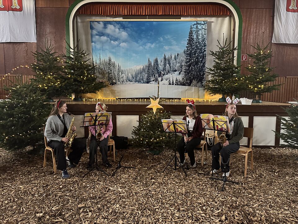 IMG 8326 Vier Mädchen mit Instrumenten. Im Hintergrund die weihnachtlich eingerichtete Schützenhalle
