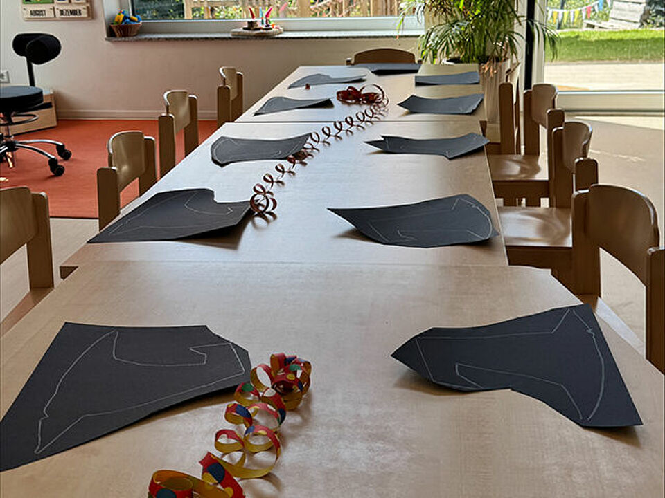 Die Vorlagen für die Hexenhüte zum Selberbasteln liegen auf einem langen Tisch für die Kinder bereit. 